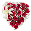 A luminous, heart-shaped floral creation rests against a pure white backdrop: dozens of deep crimson roses crowd together to form the rounded silhouette, their velvety petals ranging from tight buds to fully unfurled blooms that catch soft studio light and reveal subtle shadows and highlights. Between the roses, airy clusters of tiny white baby's breath (Gypsophila) billow like gentle cloud, threading a feathery contrast through the dense red and softening the heart's outline with a delicate halo. Nestled in the upper left curve, a single large white lily opens with sculptural grace - its pristine petals edged with the faintest cream, a central hint of yellow, and golden stamens that add a warm punctuation to the cool white. The composition reads both opulent and intimate: the tactile velvet of the roses, the whisper-thin sprays of gypsophila, and the smooth, almost waxen surface of the lily invite the fingertips to linger and the nose to imagine a faint, clean floral perfume. The white background isolates the bouquet, making the reds and whites sing with clear contrast and emphasising the florist's precise shaping of the heart. This arrangement carries a message of deep affection and calm devotion - the classic language of romance and remembrance - and would suit moments from a quiet anniversary in Shoreditch to a bold Valentine's gesture framed by the nearby glow of Brick Lane late at night. Crafted with a focused hand, the piece balances passion and purity so the sentiment reads unmistakably as love rendered in blooms.